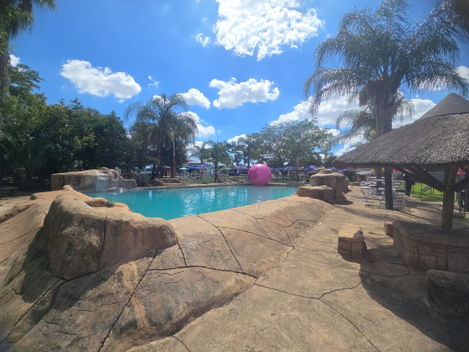 Pool area set up for a festival with branded umbrellas and seating